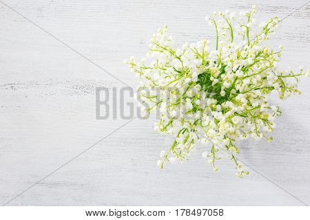 Bouquet of Lilies of the Valley  over wooden background.