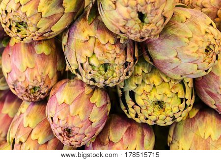 Heap of big purple Artichokes at a market stall.