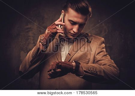 Sharp dressed man with mobile phone wearing jacket and bow tie