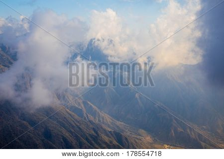 The Sun behind the clouds over mountains