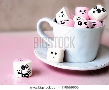 Funny photo with pastelui in white and pink colors on a pink background. Funny faces of pastely. Cheerful background with sweets.