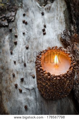 Burning Aromatic Coffee Candle And Coffee Beans On Aged Wood