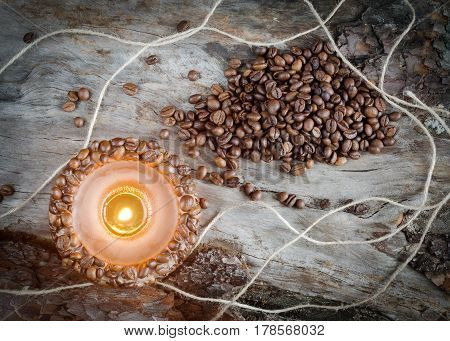 Burning Aromatic Coffee Candle And Coffee Beans On Aged Wood