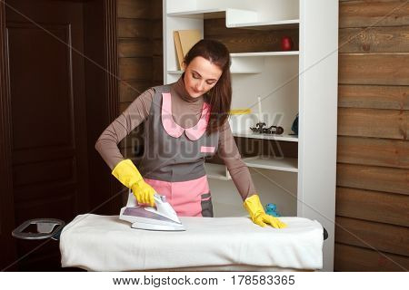 Young woman in uniform with steam iron