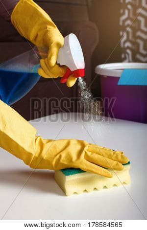 Female person hands in rubber gloves wash table