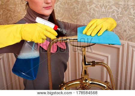 Female hands in rubber gloves cleans bathroom