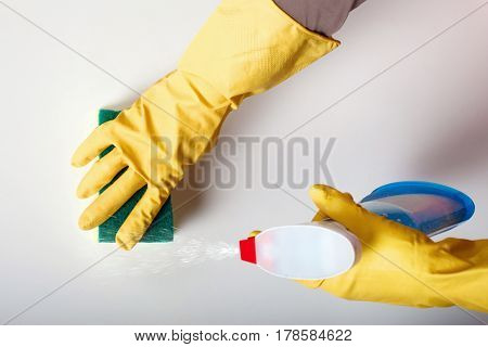 Female person hands in rubber gloves wash table