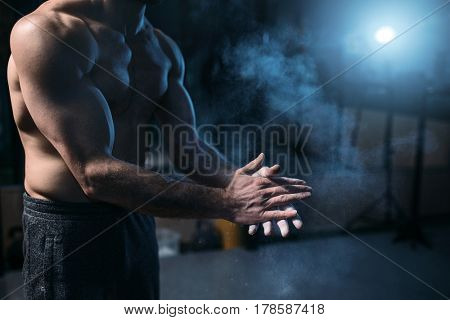 Male athlete rubs hands with talcum powder