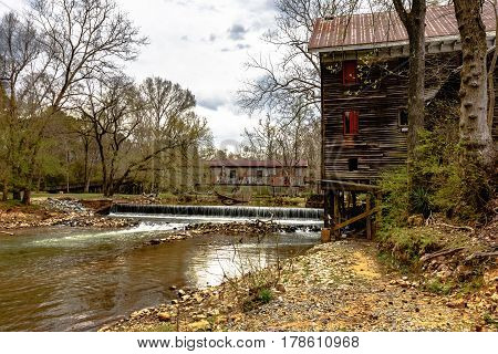 Childersburg Alabama USA - March 25 2017: Springtime at Kymulga Park. Kymulga Grist Mill on the banks of Talledega Creek with the Kymulga Covered Bridge in the background.