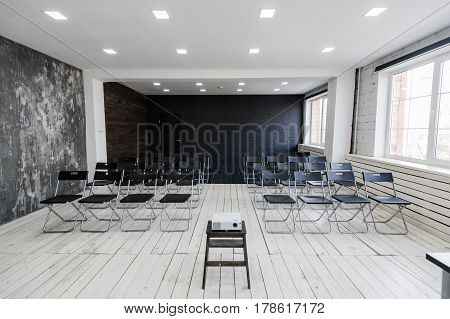 Modern university group study room with white desk and chairs.