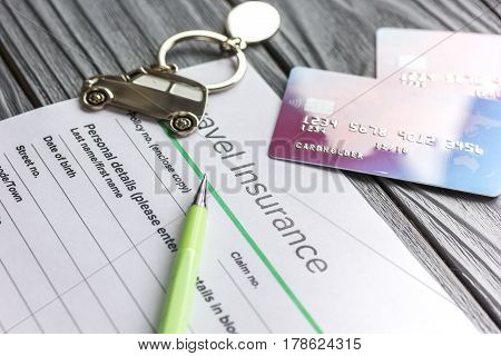 Travel preparation concept with insurance application form and credit cards for online payment on wooden table background