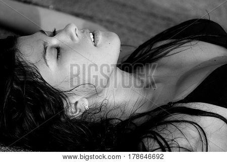 The girl lying on the sand at the beach with your eyes closed