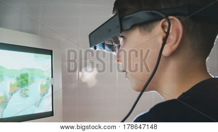 Ophthalmology - child checks eyes with stereo glasses and monitor, close-up