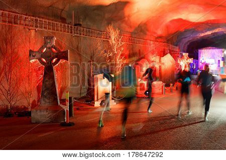 STOCKHOLM SWEDEN - MAR 25 2017: Tunnel with red light tomb stones and running people looking like ghosts the Stockholm Tunnel Run Citybanan 2017. March 25 2017 in Stockholm Sweden