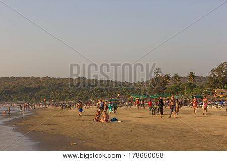 ARAMBOL BEACH GOA INDIA - FEBRUARY 23 2017: Flea market on Arambol beach at sunset in Goa India on February 23 2017. People are walking on beach.
