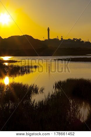 El Rompido lighthouse and marina at sunrise from marshlands Huelva Spain