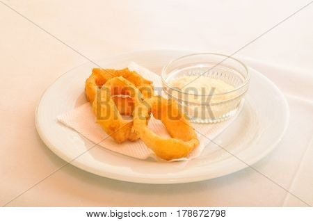 Delicious fresh calamari rings in white plate