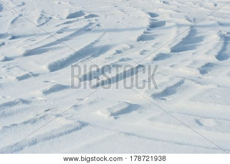 Curvy car tracks in the snow at daytime background