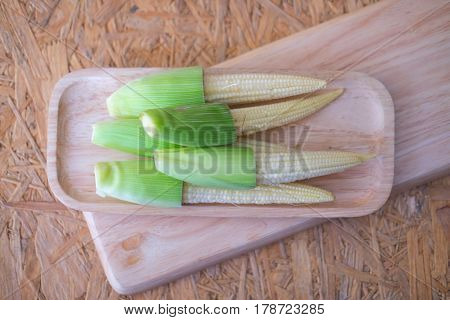 Fresh baby corn on the wood tray ready to cook