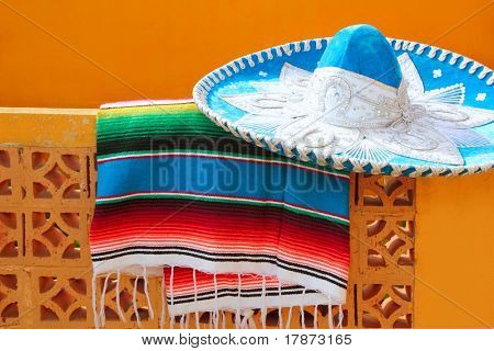 Charro mariachi blu cappello messicano serape poncho sopra la parete di piastrelle arancioni