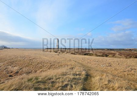 Iceland's Malarrif Lighthouse surrounded by open grass fields.