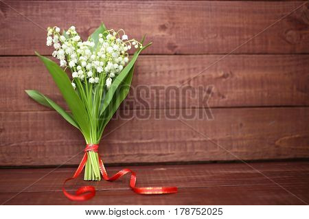 Lily of the valley on wooden background. Lily of the valley bouquet. Lily of the valley with copy space.