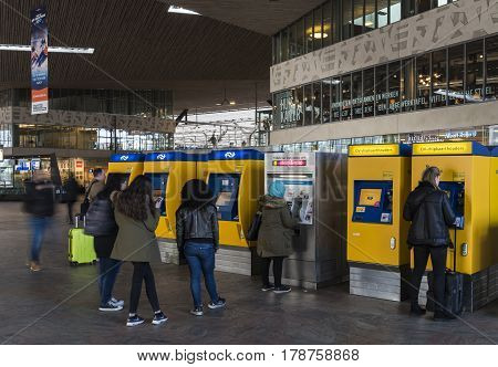 Rotterdam The Netherlands - March 10 2017: Travelers getting their tickets at the ticket machine in the railway station of Rotterdam in the Netheralnds.