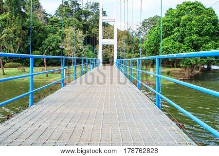 Suspension bridge for walking over river in public park.
