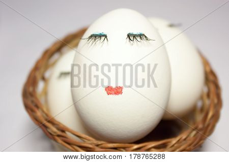 Concept Easter three eggs in a wicker basket one in the foreground