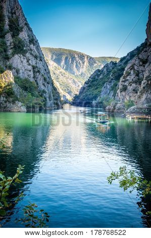 View of beautiful tourist attraction, lake at Matka Canyon in the Skopje surroundings, Macedonia. Leafs in the foreground, vertical composition.