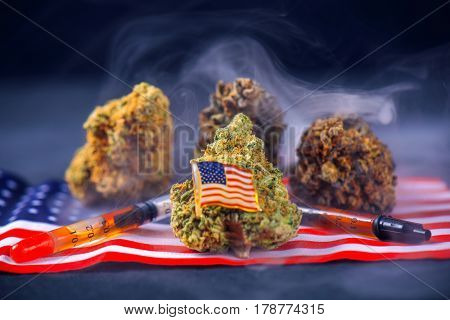 Cannabis buds and american flag with some oil extraction and smoke - veteran themed medical marijuana concept