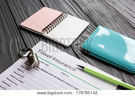 Traveling concept with insurance application form, passport and credit cards on gray wooden table background