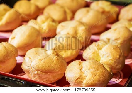 Close up of cooked homemade profiteroles on a tray