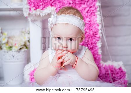 Little girl eating cake in white dress
