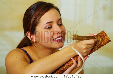 Beautiful young woman wood burning with pyrography pen