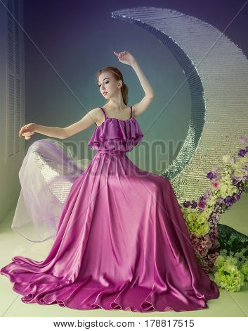 Cute girl dancer in a beautiful dress posing in the studio. Tinted photos.