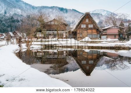 Old Style Traditional Houses With Reflection At Historic Village Shirakawago In Winter, Japan