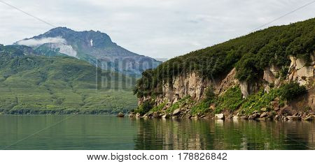 Beautiful coast of the Kurile Lake is reflected in the water.