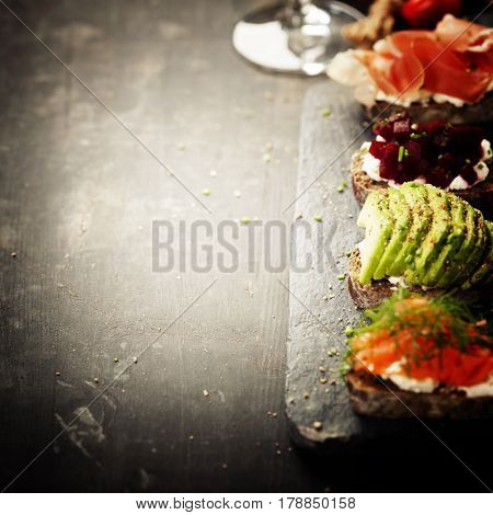 Tasty rye bread sandwiches with salmon, avocado, beetroot, creamcheese, ham, herbs and spices