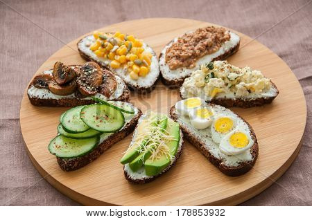 Mix Of Rye Bread Bruschettas With Various Filling. Sweet Corn Avocado Mashrooms Quail Eggs Cucumber