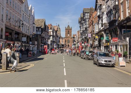 Chester England UK - March 25 2017: Shoppers and visitors on Bridge Street with its beautiful half timbered buildings and the church of Saint Peters in the historic city of Chester