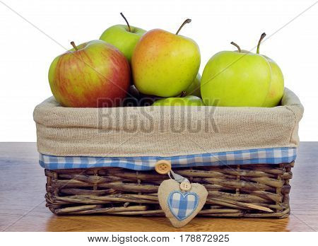 Colored Apples in a wicker basket on the table