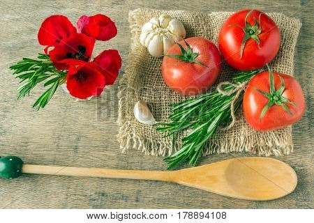 Bouquet of red poppies and rosemary. Ingredients for cooking. Concept - Mediterranean diet. Tomatoes greens garlic.