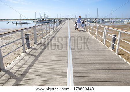People walking by footbridge at Marina of El Rompido Cartaya Huelva Spain