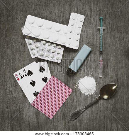 Hard drugs on dark table with playing cards three six. Demon life abstract. Dead in the end road.