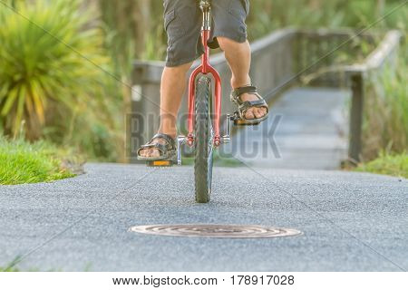outdoor portrait of young boy riding a unicycle (one wheel bike) on natural background