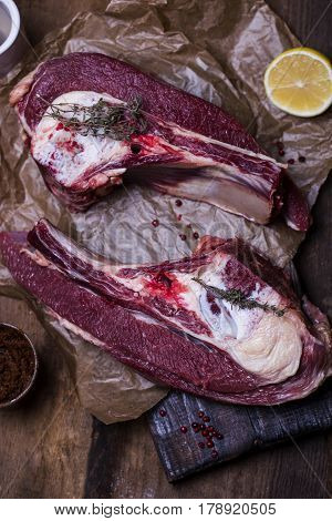 Fresh raw beef bone rib with spices on wooden background