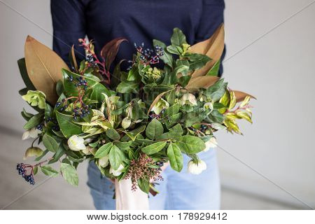 A girl is holding a bouquet in front of her on a white background