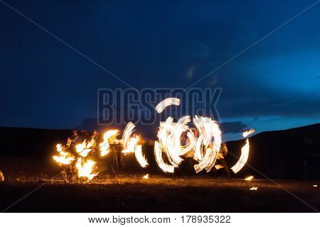 Amazing Impressive Freeze light fire show with fire trails highly in mountains with a colorful blue sky