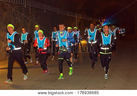 STOCKHOLM SWEDEN - MAR 25 2017: Girls in reflex vest running in a dark tunnel in the Stockholm Tunnel Run Citybanan 2017. March 25 2017 in Stockholm Sweden